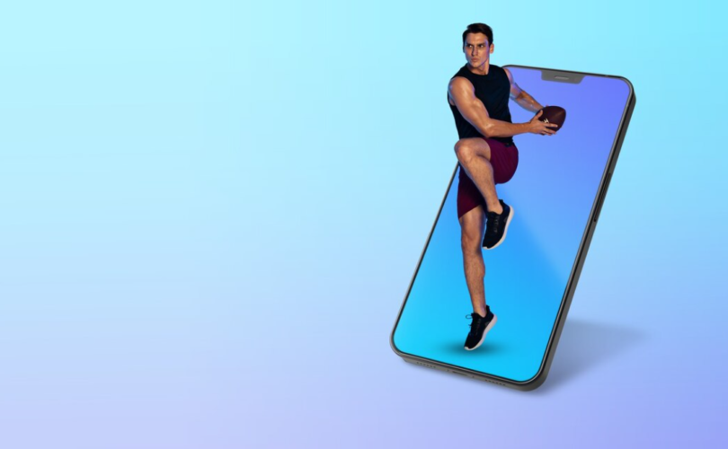A man merges from a smartphone screen holding a football